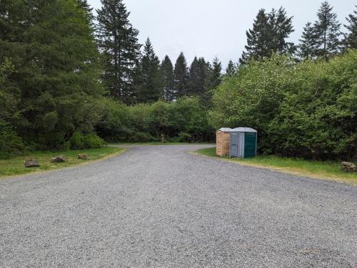 a gravel road with two buildings on the side at Tree Climbing at Silver Falls in Sublimity
