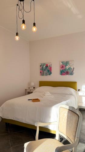 ラクイラにあるMECE Roomsの白いベッドと椅子のある寝室