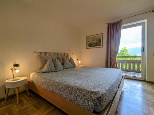 een slaapkamer met een bed en een groot raam bij Casa Lagoraiview in Carano