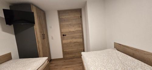 a bedroom with two beds and a sliding door at Hafner- Appartments in Saalfelden am Steinernen Meer