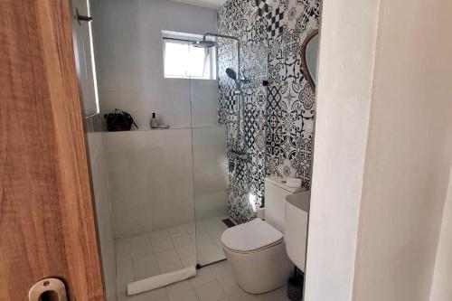 a bathroom with a shower with a toilet and a shower curtain at Tia Beach House - pool, beach and hamman in Albion