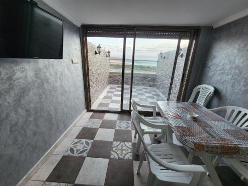 a dining room with a table and chairs and a television at Tafedna Beach House in Essaouira