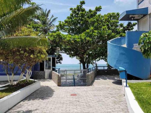 a walkway leading to a house with the ocean in the background at Anuncio teste in Guarujá