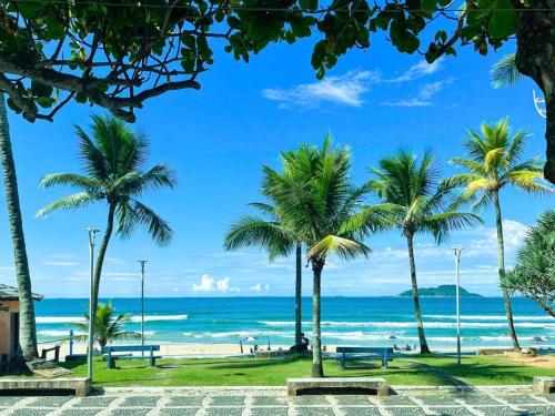 a beach with palm trees and the ocean at Anuncio teste in Guarujá