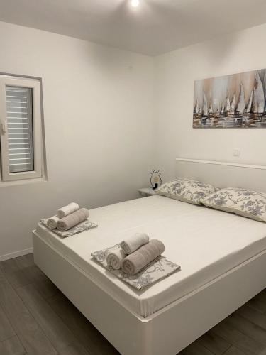 a white bed with towels on it in a bedroom at Apartments Štica- Pelješac in Janjina