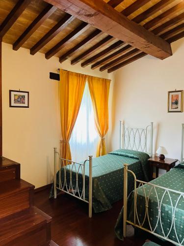 two beds in a room with a window at Agricola Caicucci in Montone
