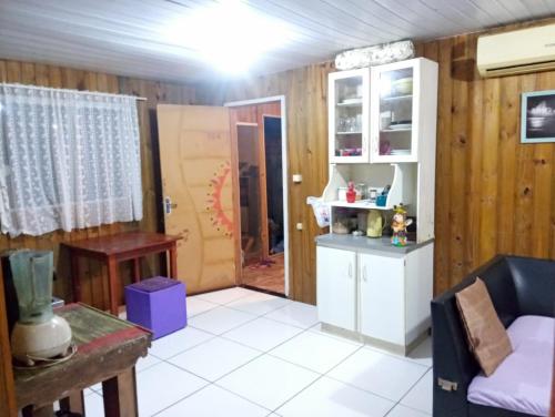 a living room with wood paneled walls and a kitchen at Inature in Florianópolis