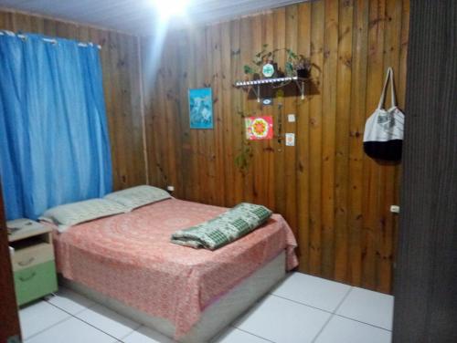 a bedroom with a bed and a wooden wall at Inature in Florianópolis