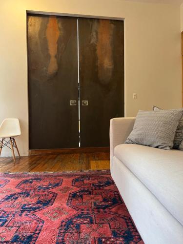 a living room with a couch and a pair of doors at Beach Street Loft in Boston
