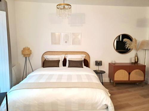 een slaapkamer met een groot wit bed en een kroonluchter bij Appartement Cosy Hyper Centre in Nantes
