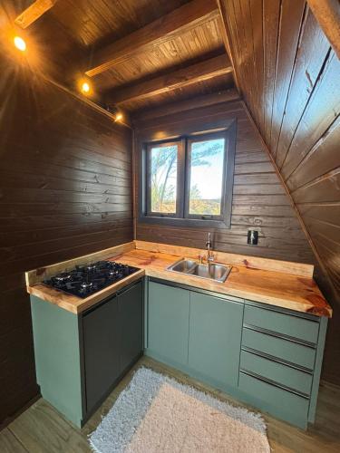 a kitchen with a sink and a stove in a room at Cabana Aroma do Mar in Jaguaruna