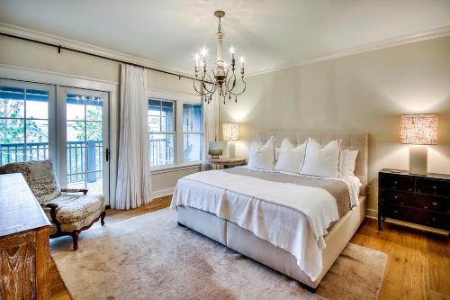 une chambre avec un grand lit et un lustre dans l'établissement Beachy Bungalow, à Santa Rosa Beach
