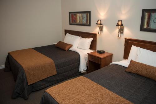 a hotel room with two beds in a room at Le Deauville Motel in Trois-Rivières