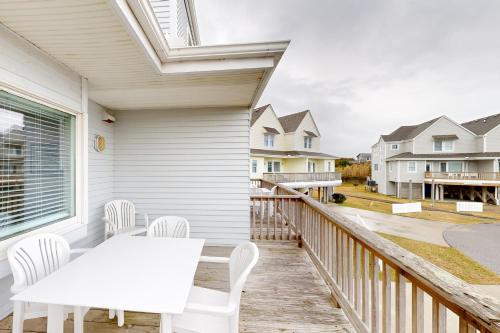 a patio with a white table and chairs on a balcony at Spot at the Cape in Buxton
