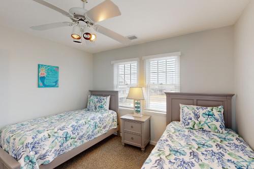 a bedroom with two beds and a ceiling fan at Spot at the Cape in Buxton