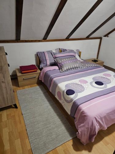 a bedroom with a bed with purple sheets and pillows at Casa de vacanța Marin in Arpaşu de Sus