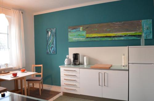 eine Küche mit einem weißen Kühlschrank und einem Tisch in der Unterkunft F1 - Kunst und Design Dresden in Dresden