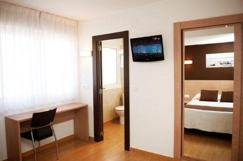 Habitación con 1 dormitorio con cama y escritorio. en Hostal Rocamar, en Santander