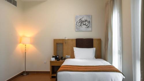 a bedroom with a bed and a lamp and a window at hotel el amri akchour in Akchour