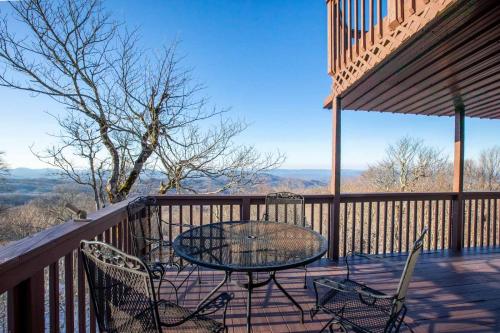 a patio with a table and chairs on a deck at Pinnacle Ridge Sunrise Sunsets in Beech Mountain