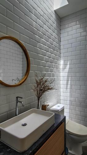 a bathroom with a sink and a toilet and a mirror at Tranquil 2BR Pool Villa - Fast WiFi - Work-Friendly - Near Echo Beach in Tumbak Bayuh