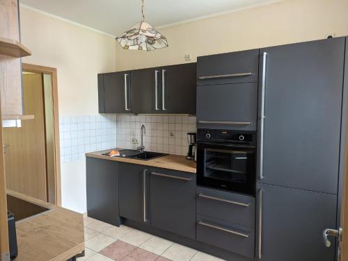 a kitchen with a refrigerator and a stove top oven at Ferienwohnungen An der Bimmelbahn Wernigerode in Wernigerode