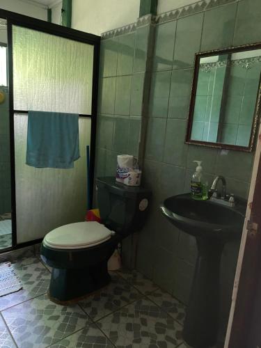a bathroom with a toilet and a sink at Finca Bosques de Osa in Palmar Sur