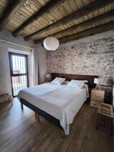 a bedroom with a bed and a stone wall at fuerte trece in Encinasola