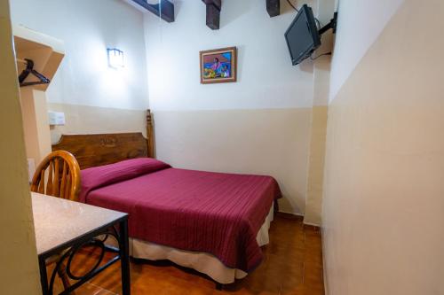 a small room with a bed and a table at Hotel el Carmen, Morelia in Morelia