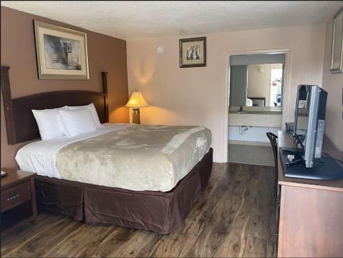a hotel room with a bed and a television at Economy Hotel Montgomery in Montgomery