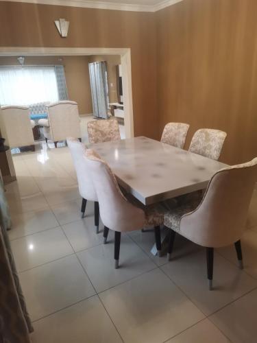 una sala da pranzo con tavolo e sedie in legno di Tina's Place a Lilongwe