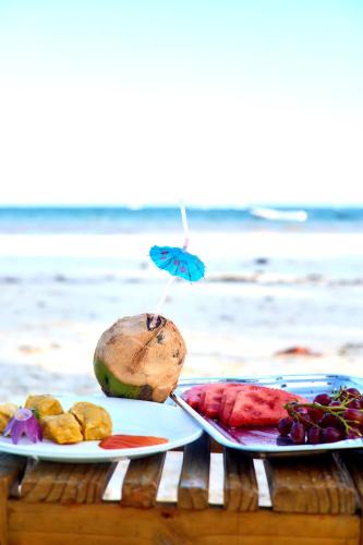 a table with two plates of food on the beach at Diani Beachfront Villa Amani at Diani in Ukunda