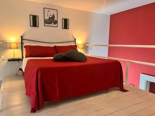 ein rotes Schlafzimmer mit einem Bett mit einer roten Decke in der Unterkunft Stupendo bilocale con soppalco vicino alla Reggia di Caserta in Caserta