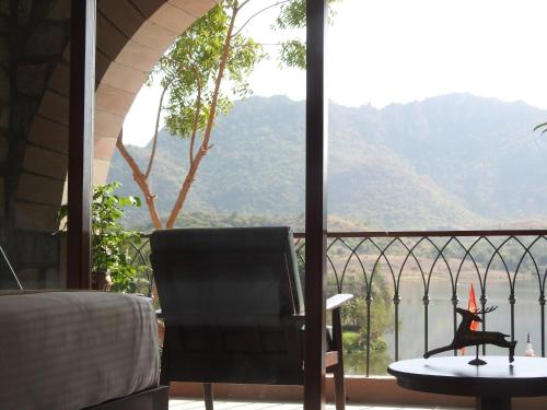 a room with a balcony with a table and a chair at Saket LOAK in Udaipur