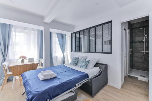 - une chambre avec un lit bleu et un bureau dans l'établissement Nets Inn Apartments - Saint Lazare, à Paris