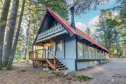 a tiny house in the woods with a red roof at Tiny Timber in Packwood