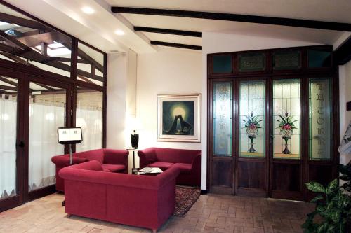 ein Wohnzimmer mit einem roten Sofa und Buntglastüren in der Unterkunft Hotel La Torre in Moie