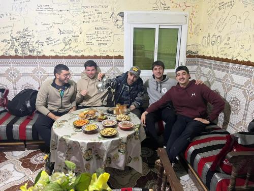 a group of men sitting around a table with food at KETAMA home stay in Tlata Ketama