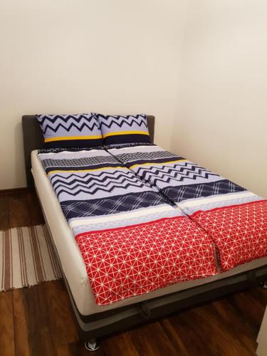 Una cama con mantas y almohadas coloridas. en Apartman ARNO, en Sarajevo