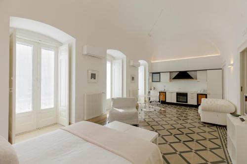 a white room with a bed and a fireplace at Antica Dimora sul Mare - Luxury Central Apartments - Molfetta in Molfetta