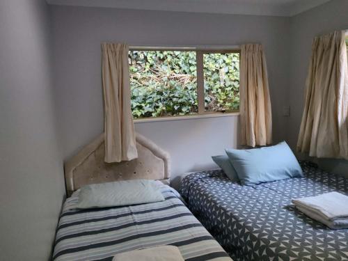 a bedroom with two beds and a window at 5 Bedroom sweet House 82A Richardson Road in Auckland