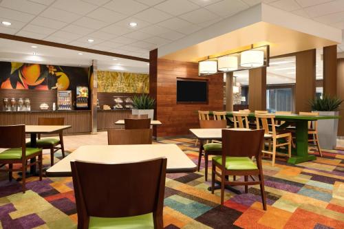 a dining room with tables and chairs and a tv at Fairfield Inn & Suites by Marriott Bristol in Bristol