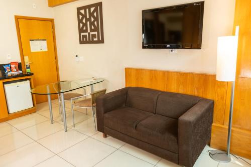 a living room with a couch and a glass table at Royal Golden Hotel - Savassi in Belo Horizonte
