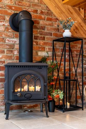 a black stove in front of a brick wall at Domki nad jeziorem Widokowo in Reszel