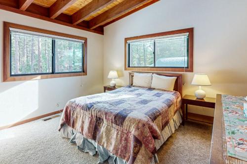 a bedroom with a bed and two windows at Tahoe City Retreat in Lake Forest