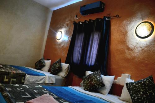 a room with two beds and a window at Kasbah Du Berger & Piscine in Merzouga