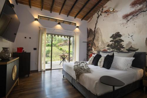 a bedroom with a large bed and a sliding glass door at GreenOriental Resort in La Vega