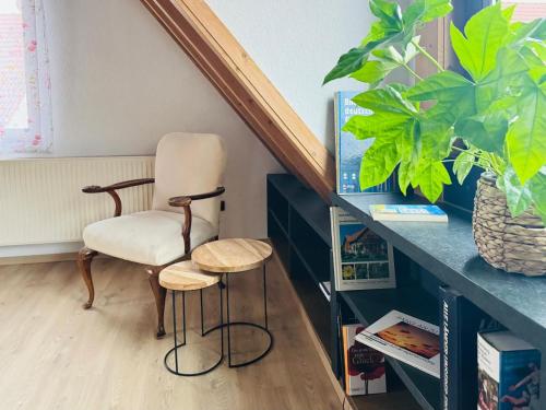 a chair and two stools in a room at Starkenburgblick in Heppenheim an der Bergstrasse
