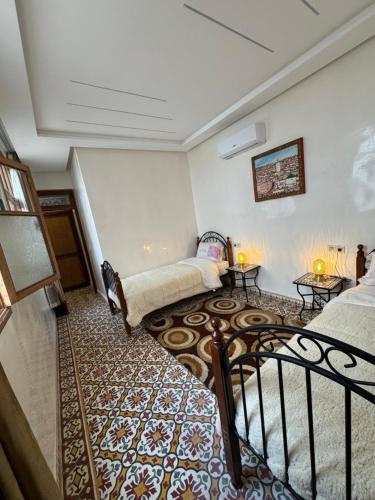 a living room with two beds and a staircase at Appartement Dar LALA 1 in Fez