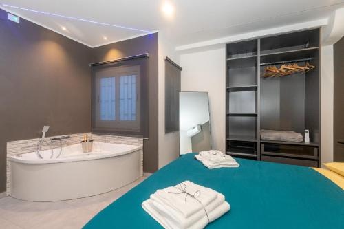 y un baño grande con bañera, lavabo y toallas. en The Cliff Appartament Suite, en Aci Castello